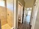 Hallway view of bathroom with shower stall, toilet and hardwood floors at 1510 Haffenberg Ave, North Port, FL 34288