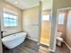 Bathroom featuring soaking tub, shower stall, toilet, window and hardwood floors at 1510 Haffenberg Ave, North Port, FL 34288