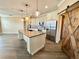 Spacious kitchen with stainless steel appliances, a large island, and modern pendant lights at 1510 Haffenberg Ave, North Port, FL 34288