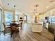 Open kitchen and living room area with wood floors and an island featuring pendant lighting at 1510 Haffenberg Ave, North Port, FL 34288