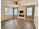 Bright living room featuring a modern fireplace, mounted TV, ceiling fan and hardwood floors at 1510 Haffenberg Ave, North Port, FL 34288