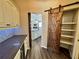Walk-in pantry featuring a wooden sliding barn door and custom shelving at 1510 Haffenberg Ave, North Port, FL 34288