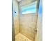Close up of shower stall with tan tile, pebble floor and window at 1510 Haffenberg Ave, North Port, FL 34288