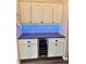 Wet bar with built-in wine refrigerator, white cabinets, herringbone backsplash, and countertop at 1510 Haffenberg Ave, North Port, FL 34288