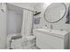 A bathroom features a sink, toilet, and shower with a gray and white color palette at 1629 Siesta Dr, Sarasota, FL 34239