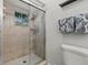 Bathroom featuring tiled shower and glass door, a towel rack with decorative towels, and a toilet at 1629 Siesta Dr, Sarasota, FL 34239