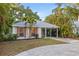 Charming single-story home featuring light gray roof, light gray trim, manicured lawn, and shuttered windows at 1629 Siesta Dr, Sarasota, FL 34239