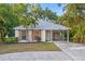 Charming single-story home featuring mature landscaping, a covered carport, and freshly painted exterior at 1629 Siesta Dr, Sarasota, FL 34239