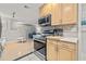 Modern kitchen featuring stainless steel appliances, wood cabinets, and an open view of the living area at 1629 Siesta Dr, Sarasota, FL 34239