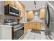 A kitchen features stainless steel appliances, light wood cabinets, and white tile flooring at 1629 Siesta Dr, Sarasota, FL 34239