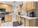 A kitchen features stainless steel appliances, wooden cabinets, and a tiled floor at 1629 Siesta Dr, Sarasota, FL 34239