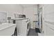 Laundry room with modern washer and dryer, a sink, and storage shelves at 1629 Siesta Dr, Sarasota, FL 34239