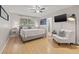 Comfortable main bedroom featuring a ceiling fan, TV, an ensuite bathroom, and large window with natural light at 1629 Siesta Dr, Sarasota, FL 34239