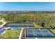 Aerial view of tennis and pickle ball courts surrounded by lush greenery at 17324 Sandpearl Rd, Venice, FL 34293