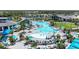 Stunning aerial view of a resort-style pool with palm trees, cabanas, lounge chairs, and manicured landscaping at 17324 Sandpearl Rd, Venice, FL 34293