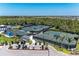 Aerial view of several well-maintained tennis courts with shaded benches and palm trees at 17324 Sandpearl Rd, Venice, FL 34293