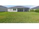 Large backyard with a green lawn, screened-in porch, and plenty of space for outdoor enjoyment at 17324 Sandpearl Rd, Venice, FL 34293