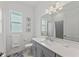 Bathroom featuring a gray vanity, a large mirror, and a shower/tub combo at 17324 Sandpearl Rd, Venice, FL 34293