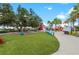 Beautiful community space with green lawn, colorful seating, and lakeside dining in a vibrant outdoor setting at 17324 Sandpearl Rd, Venice, FL 34293
