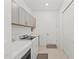 Clean laundry room with washer, dryer, utility sink, modern cabinets, and neutral flooring at 17324 Sandpearl Rd, Venice, FL 34293