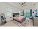 Cozy main bedroom with ceiling fan, neutral décor, and access to a balcony at 17324 Sandpearl Rd, Venice, FL 34293
