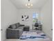 Bright home office with a gray sectional couch, modern light fixture, desk, and neutral-toned rug at 17324 Sandpearl Rd, Venice, FL 34293
