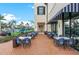 Charming outdoor dining area with blue chairs and tables near shops and lush landscaping at 17324 Sandpearl Rd, Venice, FL 34293