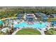 Community pool with amenities featuring poolside seating, lush greenery, and tennis courts at 17324 Sandpearl Rd, Venice, FL 34293