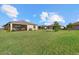 Expansive backyard with healthy green lawn and a screened-in porch on a well-maintained home at 2000 Gardenia Ave, Port Charlotte, FL 33953