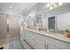 Bathroom with a double sink vanity with granite counters, and a walk-in shower with glass door at 2000 Gardenia Ave, Port Charlotte, FL 33953