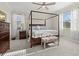 Comfortable bedroom with a four-poster bed, soft carpet, and natural light from the windows at 2000 Gardenia Ave, Port Charlotte, FL 33953