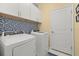 Efficient laundry area with modern appliances and stylish fish-themed backsplash at 2000 Gardenia Ave, Port Charlotte, FL 33953
