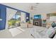 Cozy living room with a fireplace, ceiling fan, and ample natural light at 2000 Gardenia Ave, Port Charlotte, FL 33953