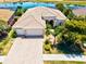 Aerial view of the house showcasing the three-car garage and surrounding landscaping at 20126 Elegante Ct, Venice, FL 34293