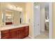 Bright bathroom featuring a vanity with dark wood cabinets and views to the walk-in closet at 20126 Elegante Ct, Venice, FL 34293