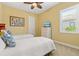 Bright bedroom features two twin beds, ceiling fan, and window with plantation shutters at 20126 Elegante Ct, Venice, FL 34293