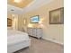 Well-lit primary bedroom featuring neutral decor and a dresser with beachside TV at 20126 Elegante Ct, Venice, FL 34293