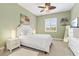 Inviting bedroom with white bedding and tropical decor, illuminated by natural light and lamps at 20126 Elegante Ct, Venice, FL 34293