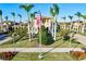 Scenic view of the Community Center with palm trees, manicured lawns, and an American flag at 20126 Elegante Ct, Venice, FL 34293