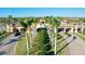 Elegant community entrance with lush landscaping, palm trees, and an arched entryway at 20126 Elegante Ct, Venice, FL 34293