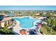 Resort-style community pool surrounded by lounge chairs, umbrellas, and palm trees at 20126 Elegante Ct, Venice, FL 34293