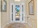 Bright and elegant foyer featuring a large entry door, high ceilings and lovely decor at 20126 Elegante Ct, Venice, FL 34293