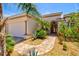 Beautiful front entrance with brick walkway, mature landscaping and a three car garage at 20126 Elegante Ct, Venice, FL 34293