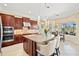 Kitchen with dark wood cabinets, stainless appliances, island seating, and breakfast nook at 20126 Elegante Ct, Venice, FL 34293
