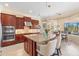 Elegant kitchen featuring a large center island, granite countertops, and pendant lighting over breakfast bar at 20126 Elegante Ct, Venice, FL 34293