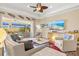 Bright living room with beach themed decor, ceiling fan, and sliding glass doors to the lanai at 20126 Elegante Ct, Venice, FL 34293