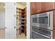 Walk-in pantry with custom shelving and built-in microwave at 20126 Elegante Ct, Venice, FL 34293