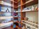 Spacious pantry with wooden shelving, pull-out drawers, and organized storage for dry goods and essentials at 20126 Elegante Ct, Venice, FL 34293