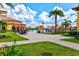 Inviting poolside patio with lush landscaping, comfortable seating, and vibrant red umbrellas at 20126 Elegante Ct, Venice, FL 34293