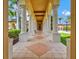 Covered walkway featuring stately columns and decorative tiled flooring at 20126 Elegante Ct, Venice, FL 34293